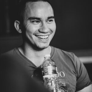 smiling man holding clear bottled water